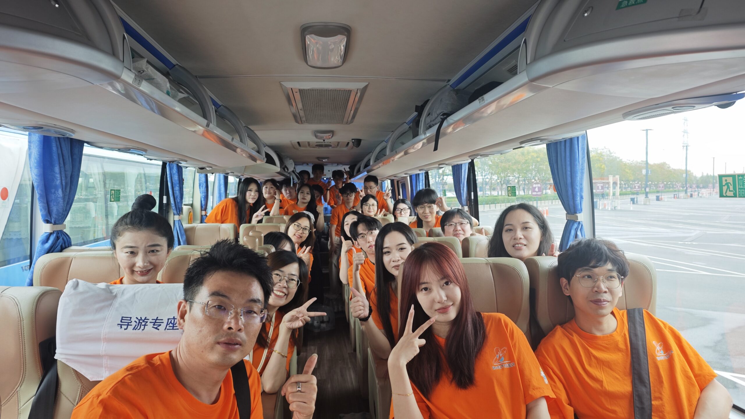 Ingtiger team members in orange shirts on the bus to Shanghai Disneyland